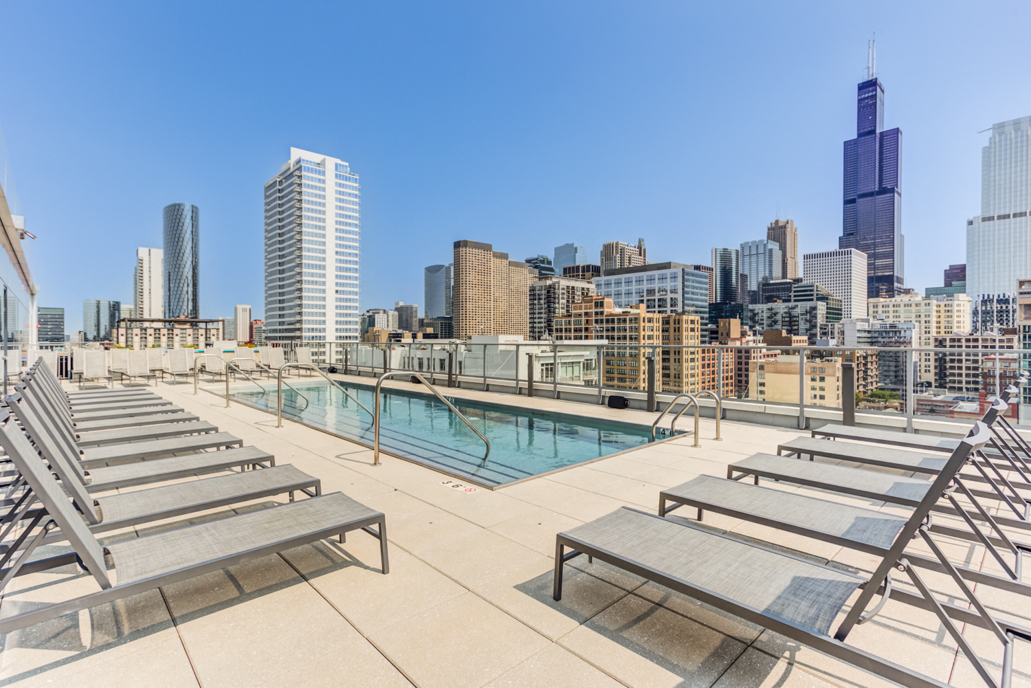 the pool on the rooftop of a building with the city in the background