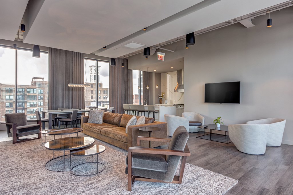 a living room with a couch and chairs and a tv