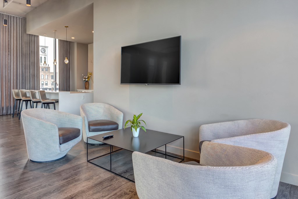 a living room with chairs and a table and a television