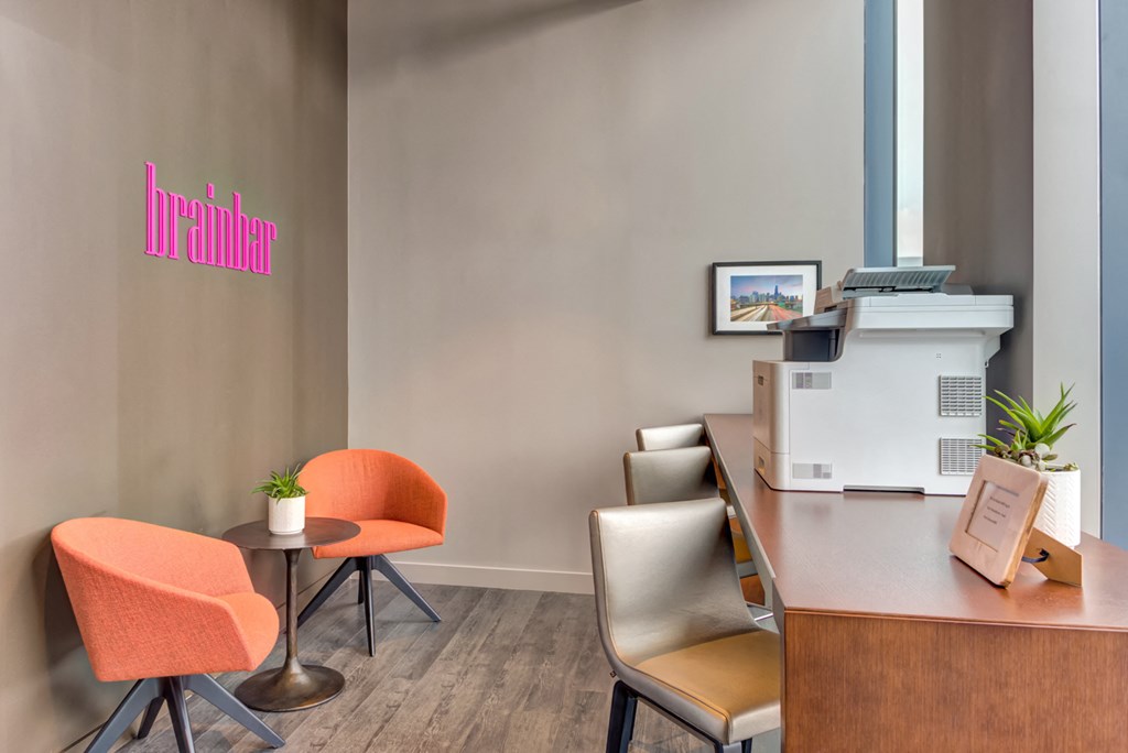 a room with a desk and chairs and a printer