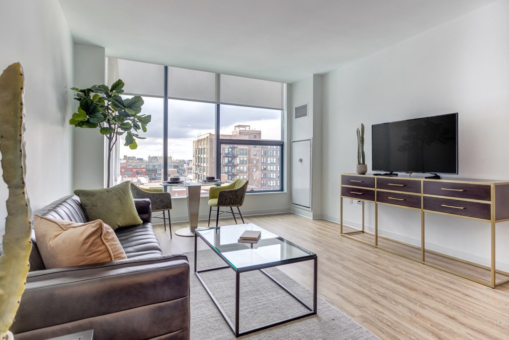 a living room with a couch and a glass coffee table and a television
