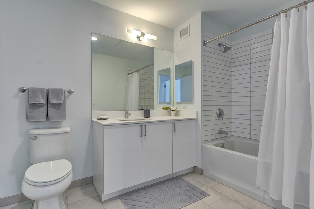 a bathroom with a toilet sink and shower and a mirror