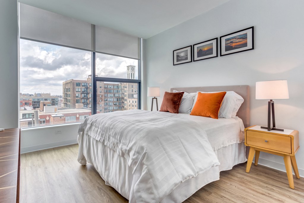 a bedroom with a bed and a large window