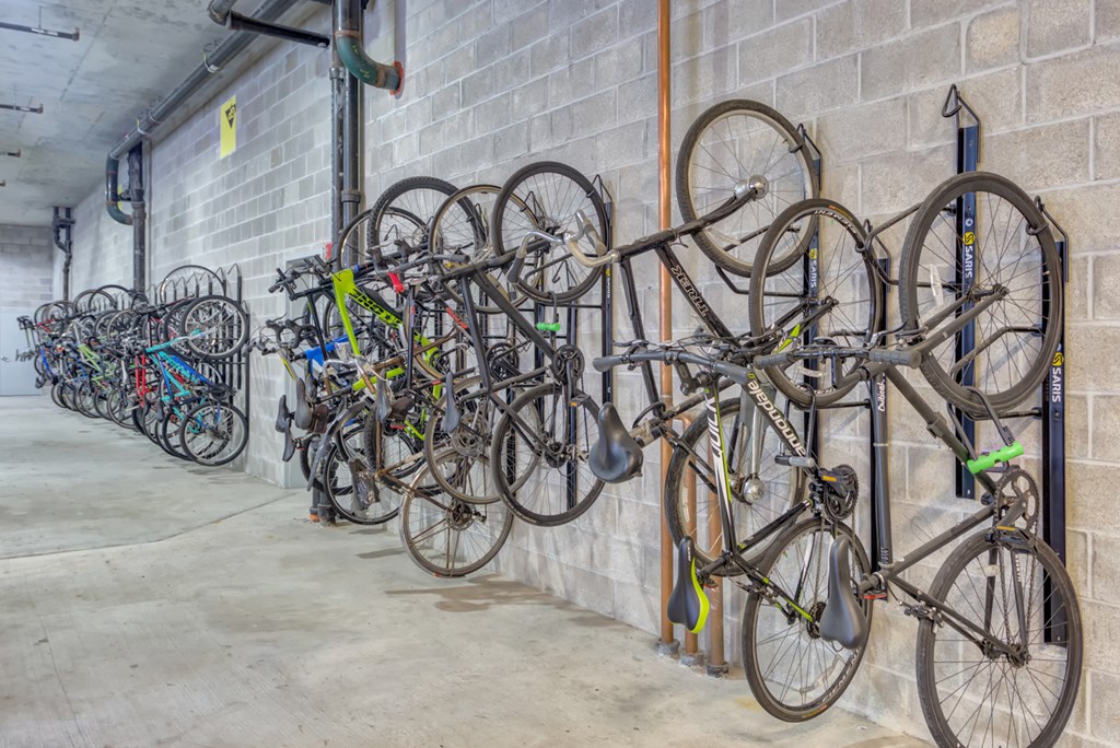 a row of bikes hanging on a wall in a parking garage