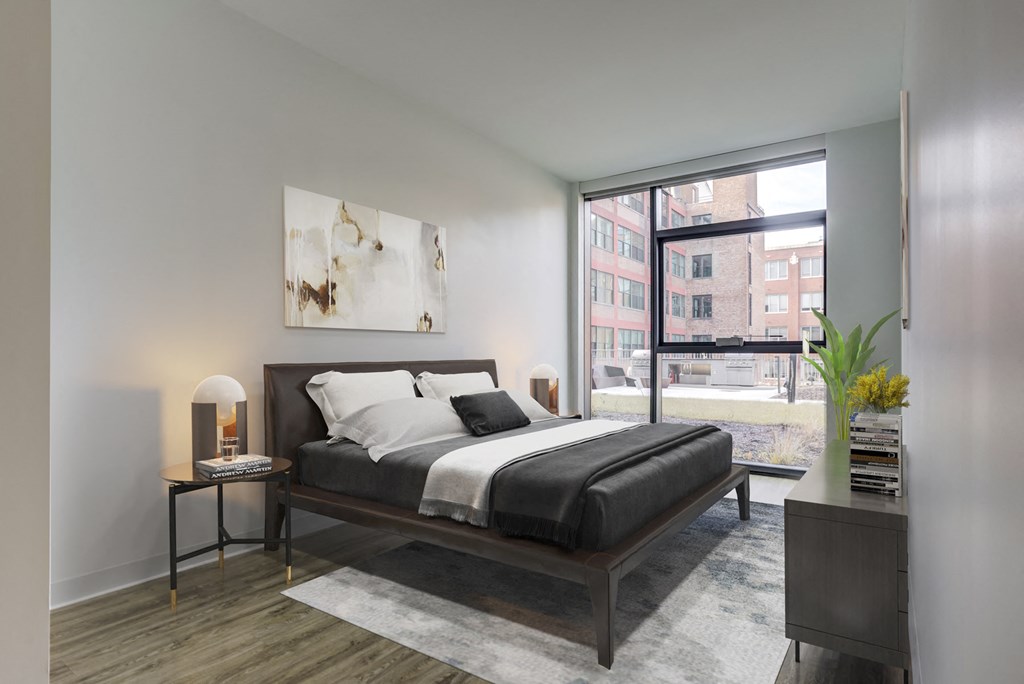 a bedroom with a bed and a large window