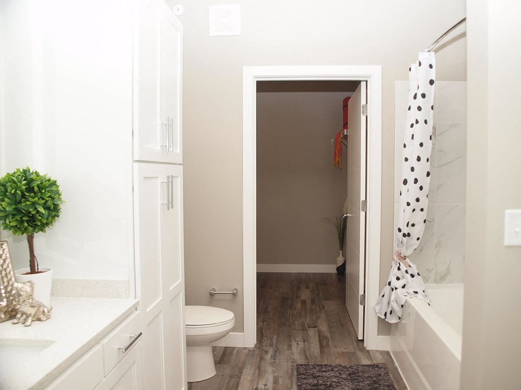 a bathroom with a white toilet and a black and white shower curtain