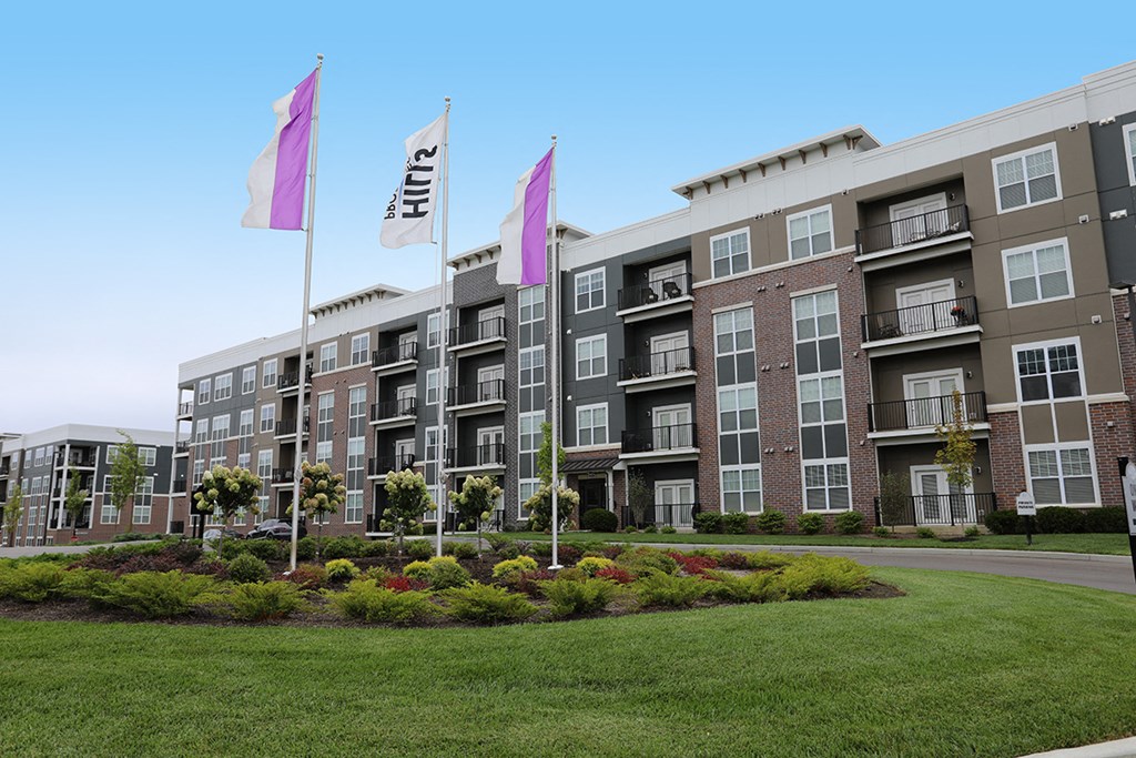 an apartment building with flags in front of it