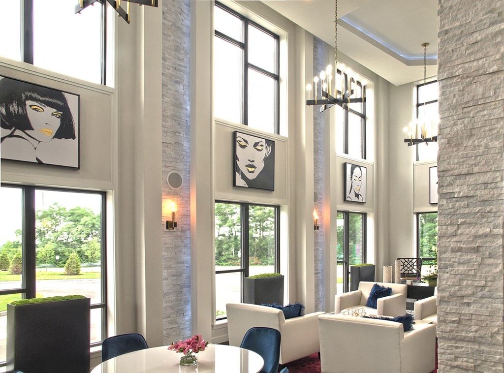 a living room with a table and chairs and large windows