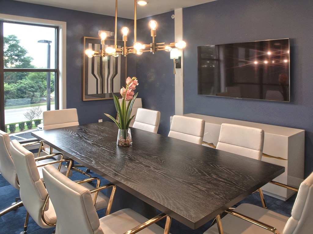 a dining room with a long wooden table and white chairs