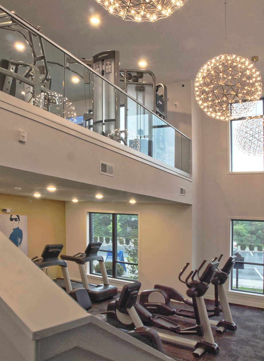 a gym with cardio machines and a chandelier