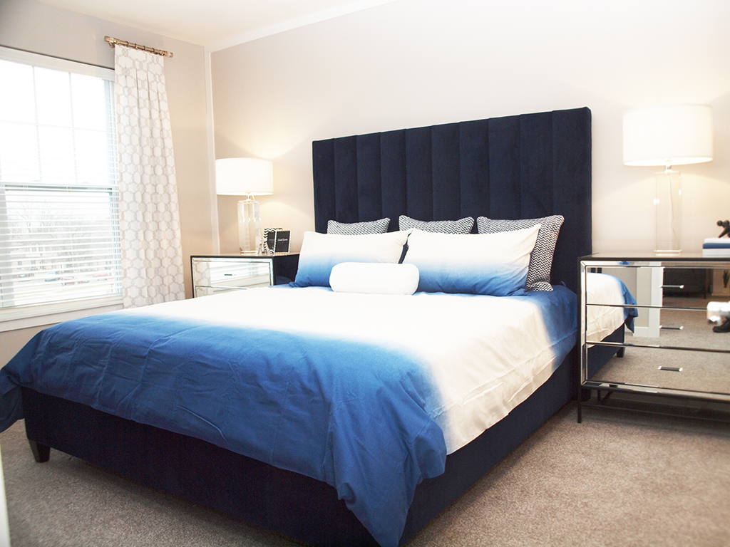 a blue and white bedroom with a bed and a window