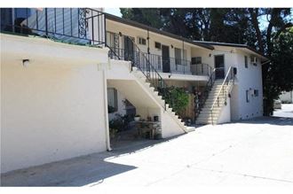 a white house with a staircase and a yard