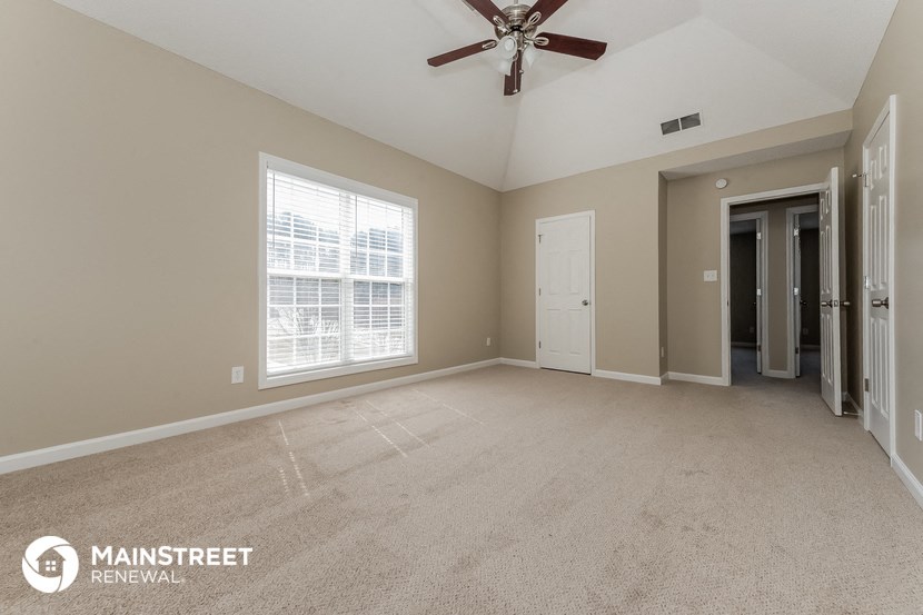 the master bedroom is spacious and clean with a ceiling fan