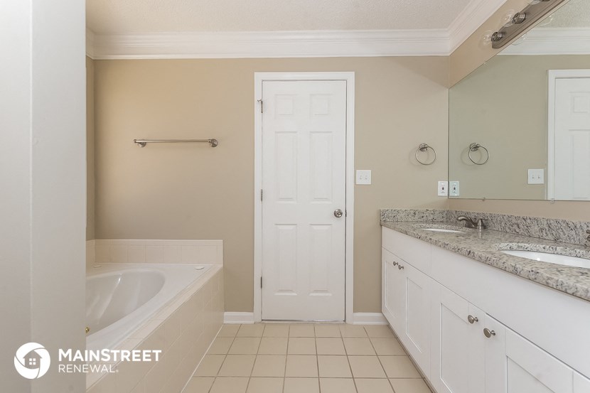a bathroom with a tub and a sink and a door