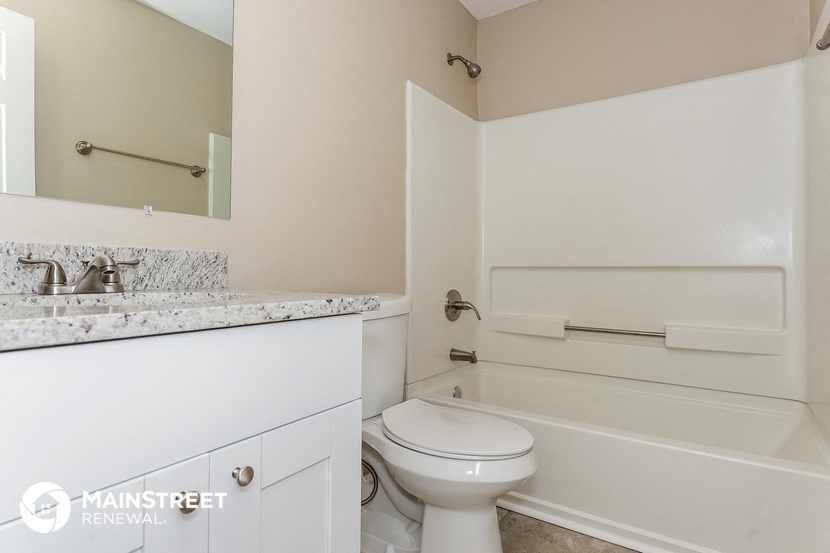 a bathroom with a toilet and a tub and a sink