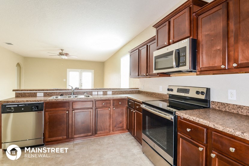 a kitchen with wooden cabinets and stainless steel appliances