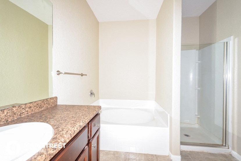 a bathroom with a tub and a sink and a shower