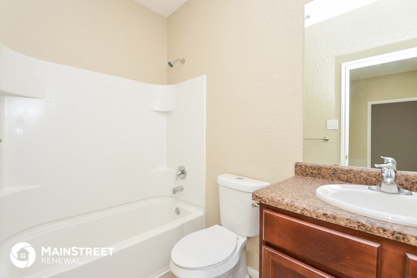 a bathroom with a toilet sink and tub and a mirror