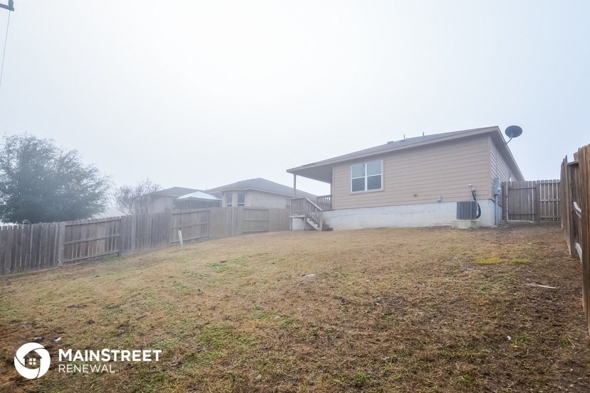 a foggy backyard with a house and a fence