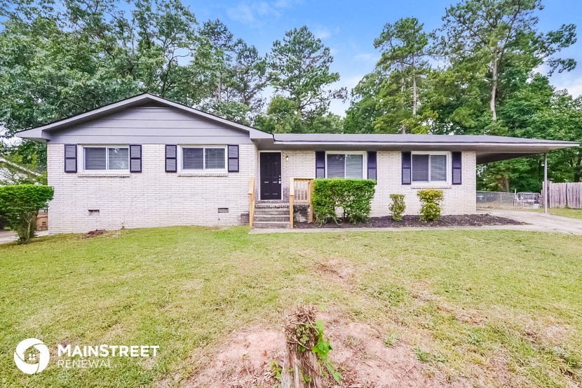 a white brick house with a lawn and trees
