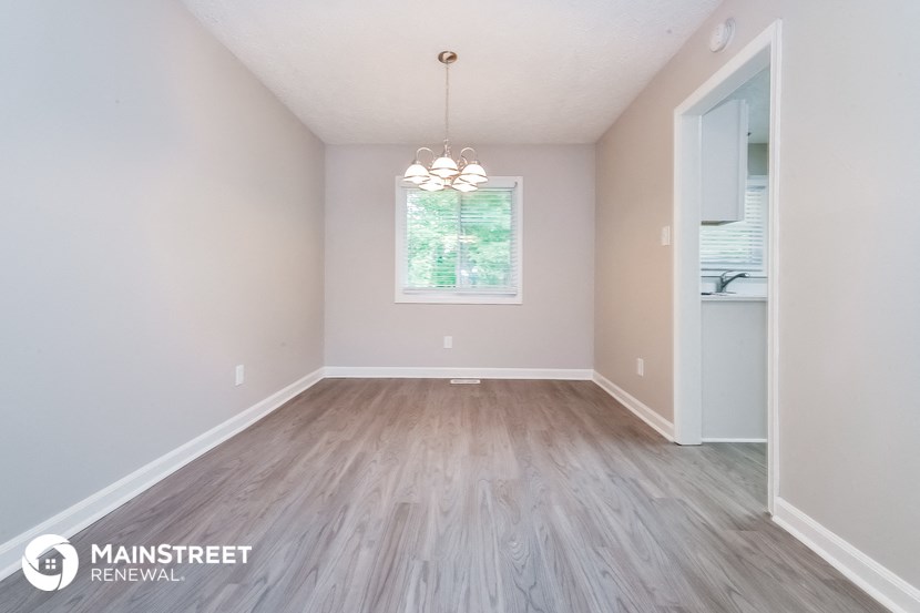 the spacious living room with wood flooring and a large window
