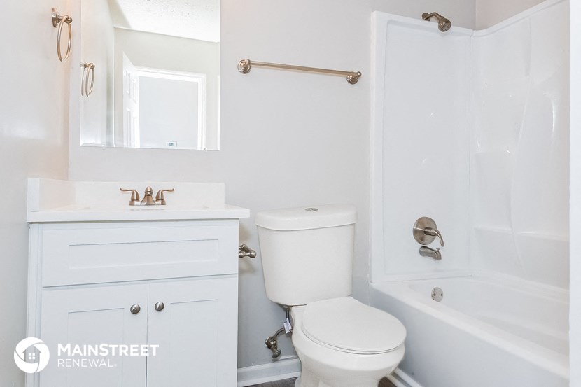 a white bathroom with a toilet and a tub and a sink