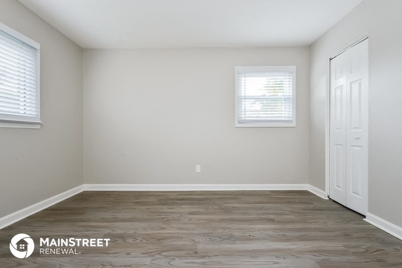 the interior of an empty room with wood floors and white walls