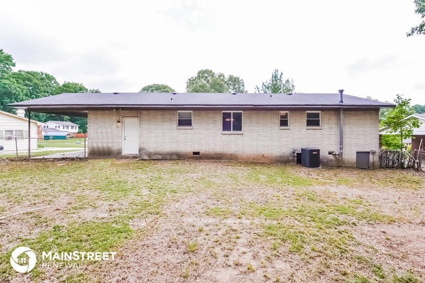 a small brick house with a yard in front of it