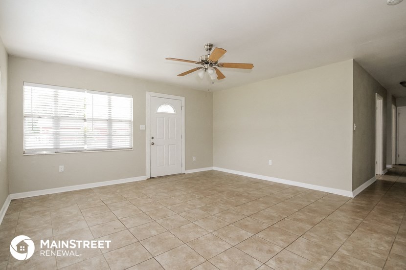 the living room of an empty house with a ceiling fan