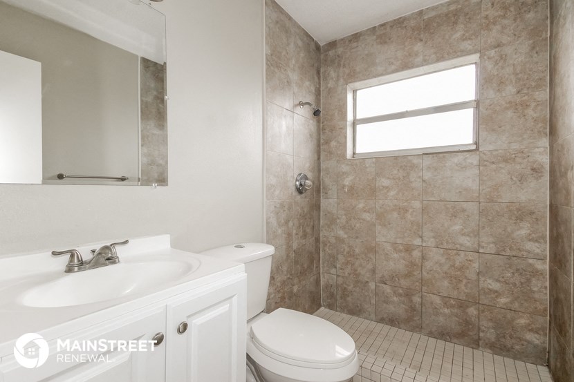 a bathroom with a toilet and a sink and a window