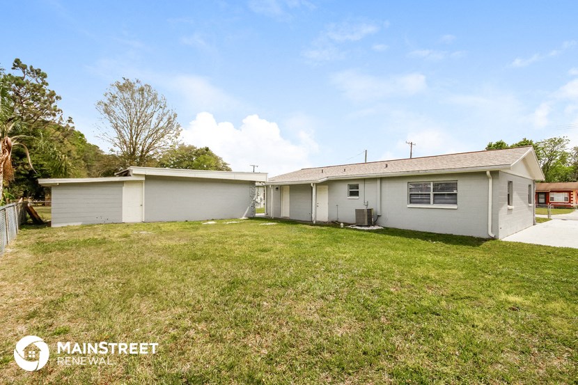 the exterior of a white house with a grassy yard