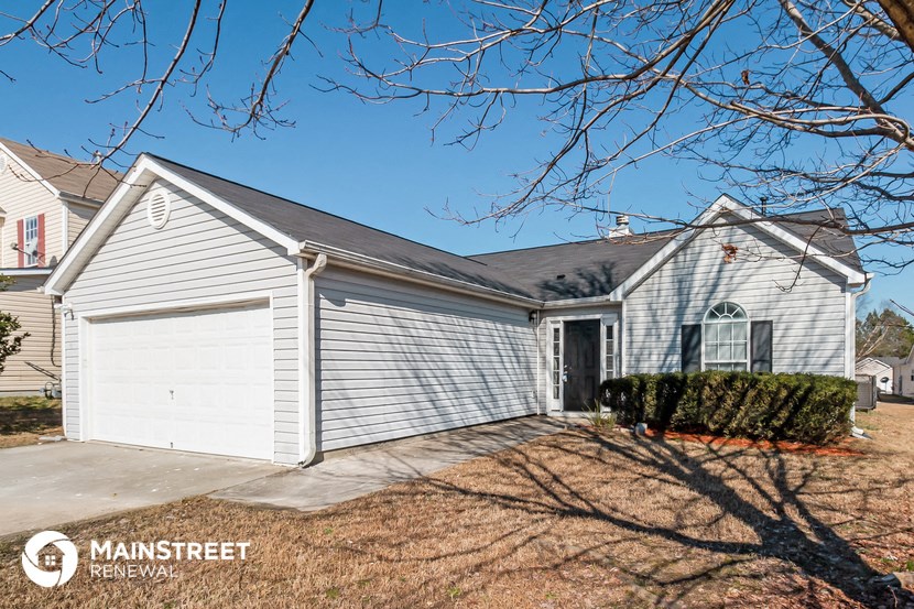 the front of a white house with a garage