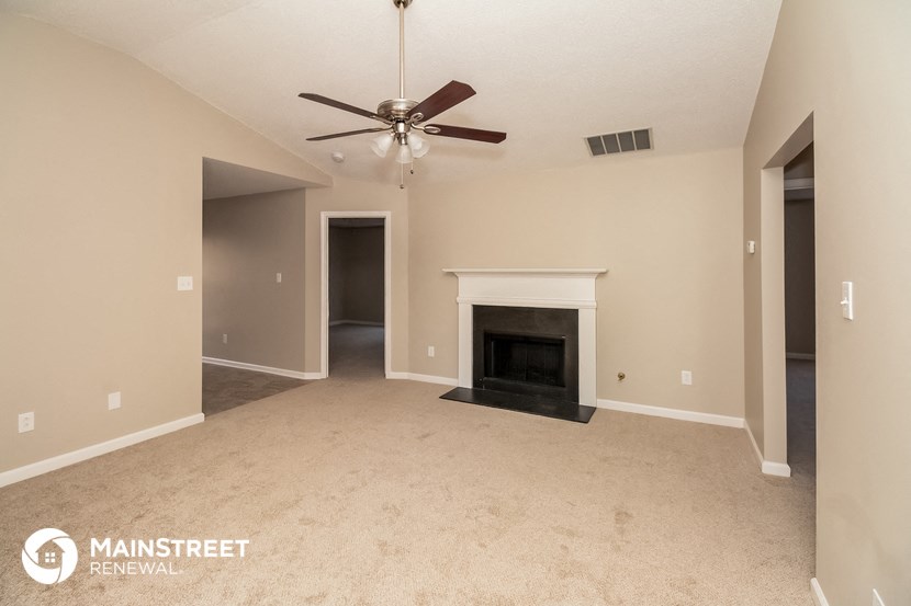 the living room with fireplace and ceiling fan