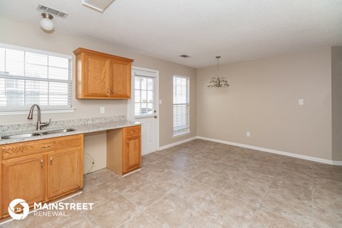 a kitchen and living room with a sink and a counter top