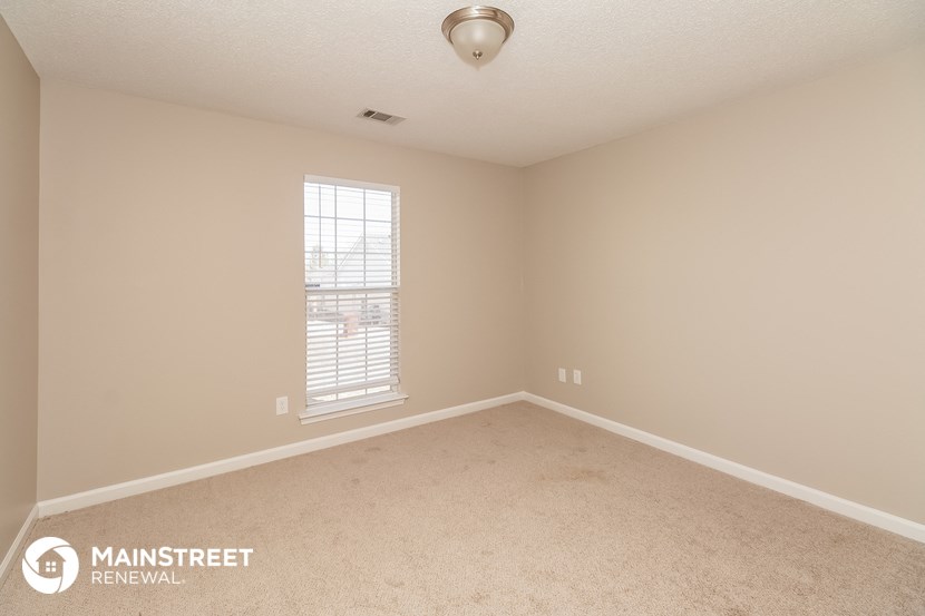 a bedroom with carpet and a window