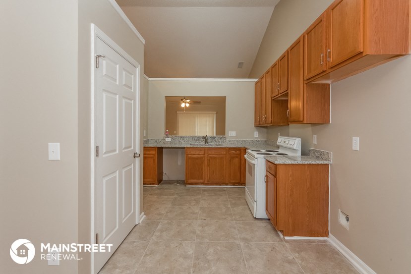a kitchen with wooden cabinets and a white stove and refrigerator