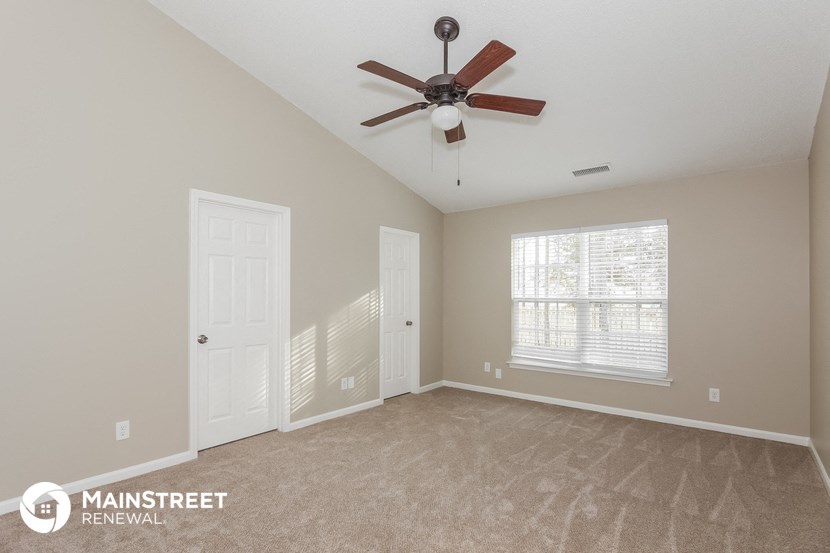 the master bedroom is spacious and has a ceiling fan