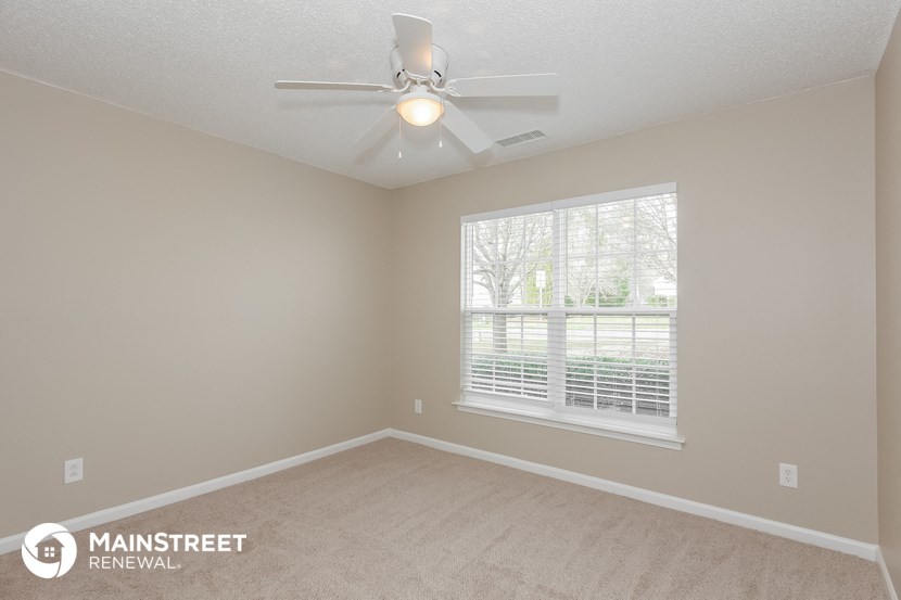 a bedroom with a ceiling fan and a window