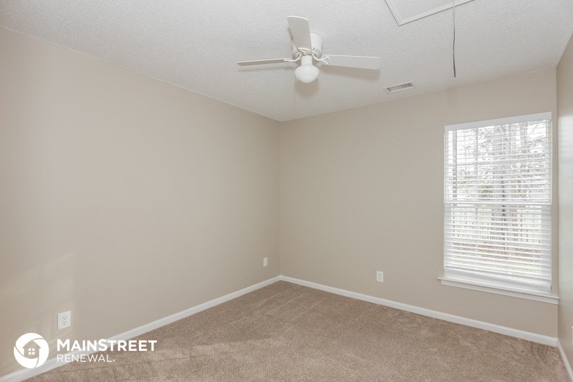 a bedroom with a ceiling fan and a window