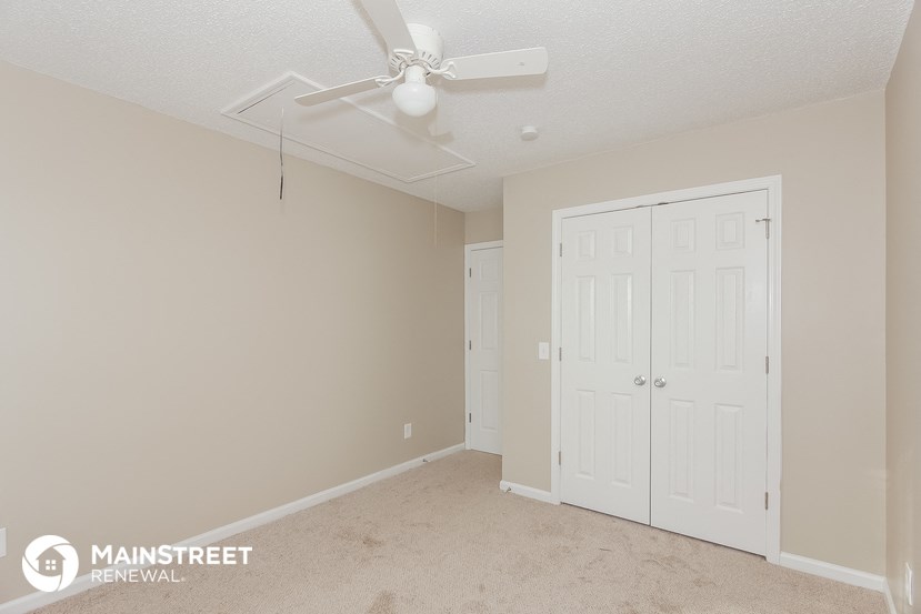 a bedroom with two closets and a ceiling fan