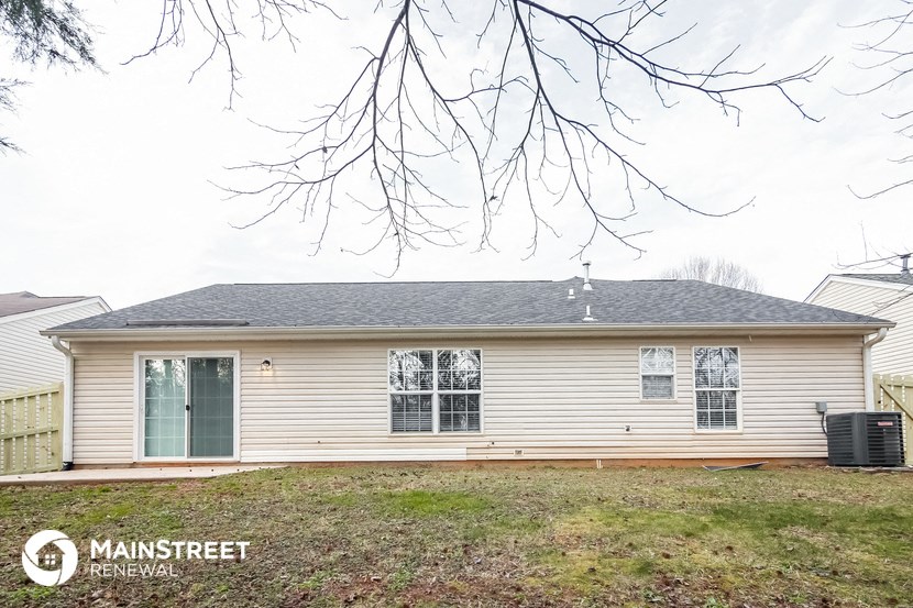 a small white house with a yard in front of it