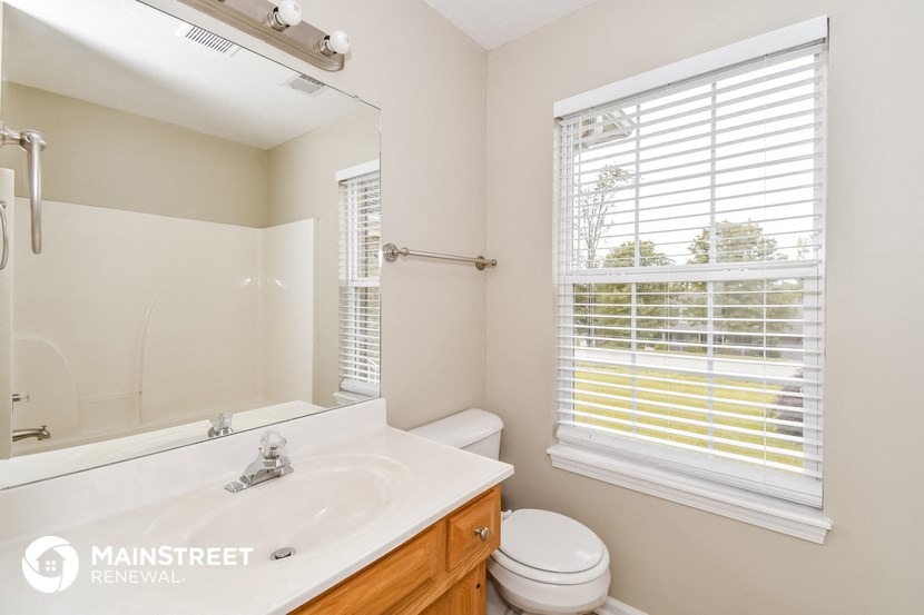 a bathroom with a large mirror and a toilet and a sink