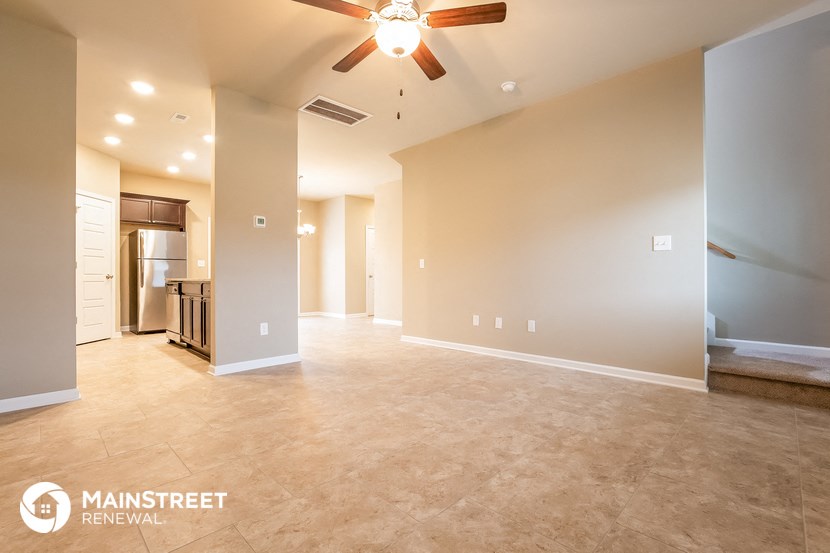 the spacious living room with the kitchen in the background