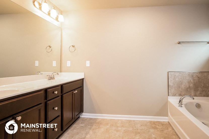 a bathroom with a sink and a tub and a mirror