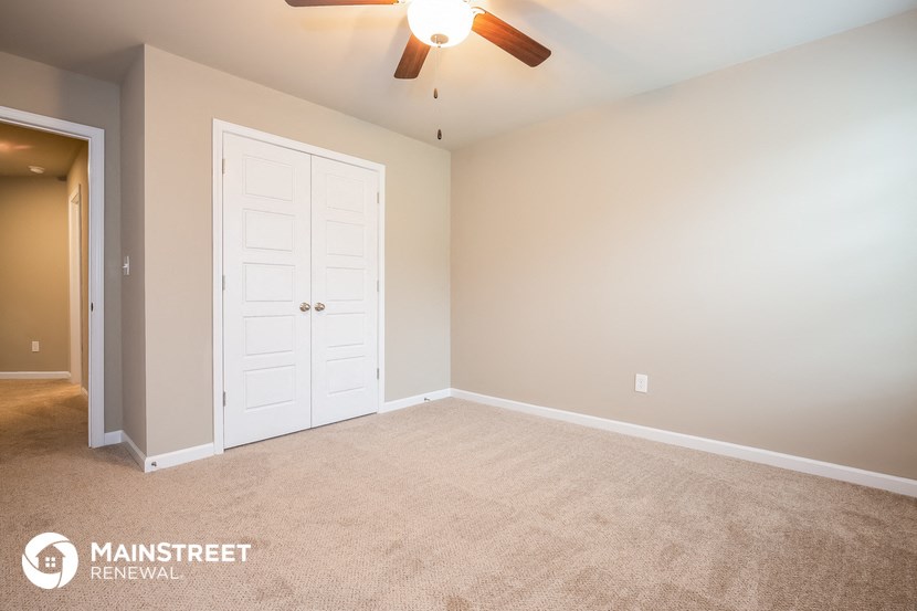 the master bedroom has a large closet and a ceiling fan