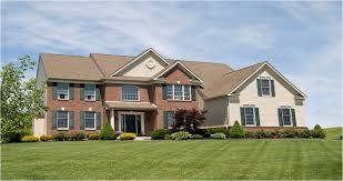 a large brick house with a green lawn