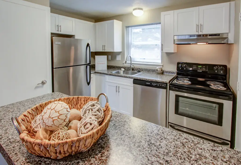 A kitchen with granite countertops and stainless steel appliances.