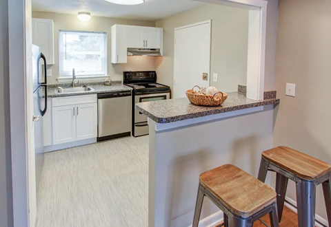 A kitchen with white cabinets and a black stove top oven.