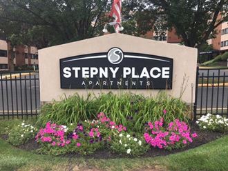 a sign for steppy place apartments in front of flowers