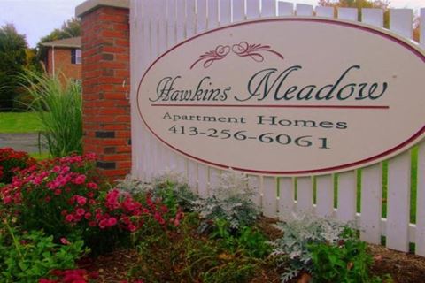 a sign for tenants meadow apartments homes in front of a fence